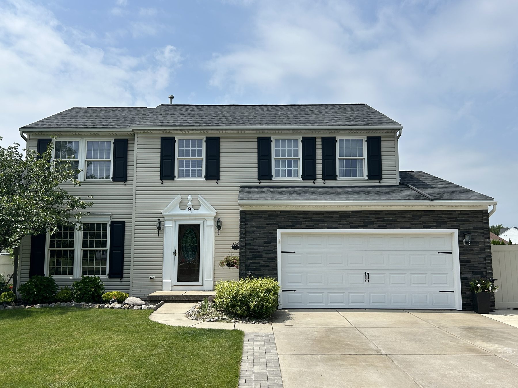 Finished exterior — siding, stone, and new front door